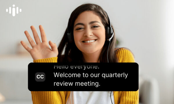 Picture of a woman smiling. Closed captions are on the picture. The captions read: Welcome to our quarterly review meeting.